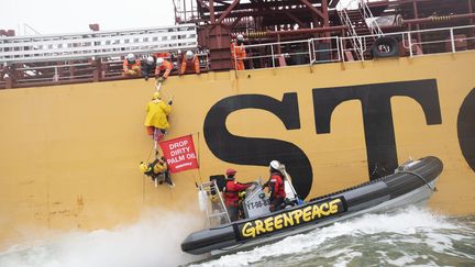 Des militants de Greenpeace manifestent sur un cargo qui s'apprête à amarrer à Rotterdam (Pays-Bas), samedi 24 novembre.&nbsp; (MARTEN  VAN DIJL / GREENPEACE NETHERLANDS)