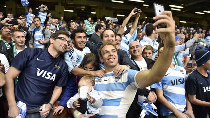 Le troisième ligne des Pumas Leonardo Senatore pose pour un selfie au milieu des fans argentins, le 18 octobre 2015 à Cardiff (Pays de Galles), après la victoire de l'Argentine contre l'Irlande, en quart de finale de la Coupe du monde de rugby. (FRANCK FIFE / AFP)