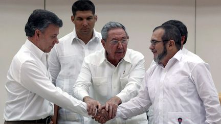 &nbsp; (Moment historique : le président colombien Juan Manuel Santos et le chef des FARC Timochenko se serrent la main à La Havane, le 23 septembre, en présence de Raul Castro © MaxPPP)