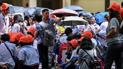 Des personnes ayant évacué un immeuble de Manille, aux Philippines, après un séisme de magnitude 6,2, le 15 juin 2023. (JAM STA ROSA / AFP)