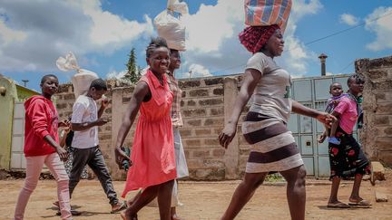 Des jeunes femmes rentrant chez elles avec des sacs de nourriture donnés par des organisations locales. Depuis le couvre-feu, des groupes de bénévoles se sont organisés pour livrer de la nourriture et des produits de base, comme le savon. Elles ciblent principalement les personnes âgées et les pauvres. Les vendeurs de rue ont été particulièrement impactés, car ils ont dû stopper leurs activités. &nbsp;&nbsp; (DONWILSON ODHIAMBO / SOPA IMAGES / SIPA)