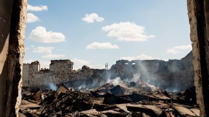 Des céréales de blé dans un entrepôt de stockage situé à cinq kilomètres des forces russes dans la région de Kherson continuent de brûler trois semaines après le bombardement du site à Mykolaïv, en Ukraine, le 22 juillet 2022. (MACIEK MUSIALEK / NURPHOTO / AFP)