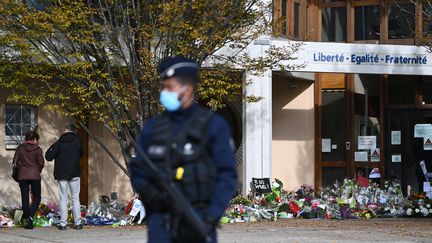 Des fleurs sont déposées au&nbsp;collège du Bois d'Aulne, à&nbsp;Conflans-Sainte-Honorine (Yvelines), le 19 octobre 2020, trois jours après l'assassinat de Samuel Paty. (ANNE-CHRISTINE POUJOULAT / AFP)