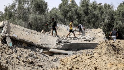 Des personnes inspectent une maison détruite à la suite d'une frappe aérienne israélienne, à Khan Yunis, dans le sud de la bande de Gaza, le 6 août 2022. (SAID KHATIB / AFP)