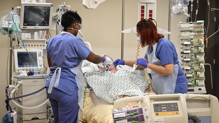 Des&nbsp;soignants s'occupent d'un patient atteint du Covid-19 placé en réanimation, à l'hôpital Avicenne de Bobigny (Seine-Saint-Denis), le 8 février 2021. (BERTRAND GUAY / AFP)