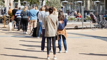 Une file d'attente devant un café sur la promenade de la station thermale de Timmendorfer Strand, dans le Land du Schleswig-Holstein, en Allemagne, dimanche 9 mai 2021. (GEORG WENDT / DPA / AFP)