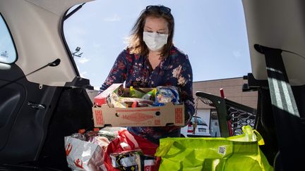 Une femme décharge une livraison du coffre de sa voiture. Photo d'illustration. (DAVID THIERRY / MAXPPP)