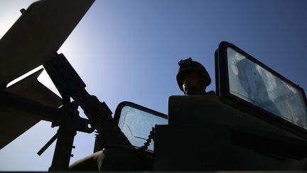 La silhouette d'un agent de sécurité afghan est visible à un poste de contrôle à Jalalabad, en Afghanistan, le 23 juin 2021. Photo d'illustration. (GHULAMULLAH HABIBI / EPA)