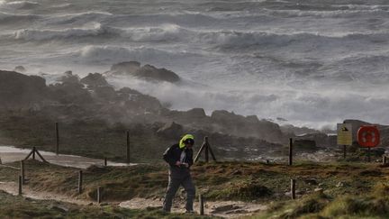 Un promeneur lors du passage de la tempête Darragh, le 7 décembre 2024, à Plomeur (Finistère). (FRED TANNEAU / AFP)