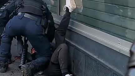 Capture écran de la vidéo où un policier frappe un manifestant au sol.&nbsp; (- / HANDOUT)