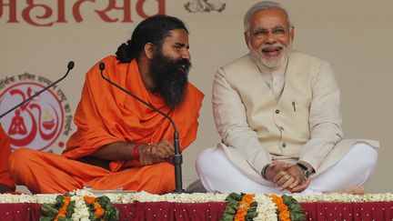 Le Premier ministre indien, Narendra Modi (&agrave; droite), et le ma&icirc;tre de yoga baba Ramdev, lors d'un festival de yoga, &agrave; New Delhi (Inde), le 23 mars 2014. (ADNAN ABIDI / REUTERS)