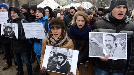 Des Ukrainiens portent les photos de personnes tu&eacute;es. Le 23 janvier 2014, &agrave; Lviv. (YURIY DYACHYSHYN / AFP)