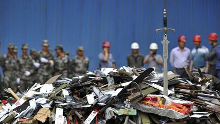 Des milliers d'armes ill&eacute;gales confisqu&eacute;es par les autorit&eacute;s attendent d'&ecirc;tre d&eacute;truites dans une usine pr&egrave;s de Kunming (Chine), le 12 juin 2012. (WONG CAMPION / REUTERS)