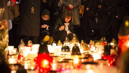 Une femme dépose une bougie, le 30 octobre 2017 à Varsovie, à l'endroit où un chimiste de 54 ans, Piotr S.,&nbsp;s'est immolé par le feu pour protester contre le pouvoir conservateur&nbsp;en Pologne. (MACIEJ LUCZNIEWSKI / NURPHOTO/ AFP)