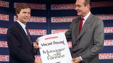 Le Premier ministre de l'époque, Jacques Chirac, remet le 14 octobre 1987 à Paris le prix de Manager de l'année, décerné par "Le nouvel Economiste" à Vincent Bolloré, président de l'entreprise Bolloré Technologies. (JOEL ROBINE / AFP)