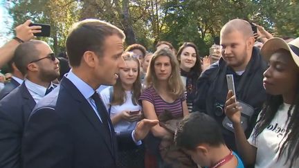 Emmanuel Macron discute avec un chômeur dans les jardins de l'Elysée, à Paris, à l'occasion des Journées du patrimoine, le 15 septembre 2018. (POOL / FRANCETELEVISIONS)