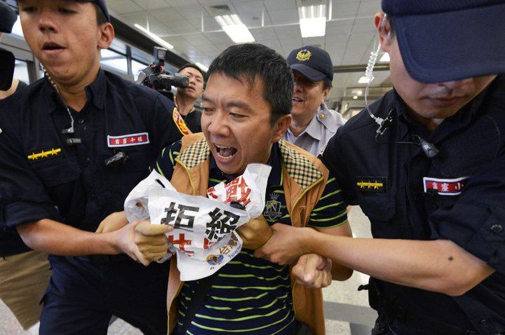 Ce militant est évacué par la police, le 22 août 2016, après avoir crié «Sha, va-t-en!» Les Taïwanais sont en effet très partagés quant au rapprochement avec la Chine. (SAM YEH / AFP)