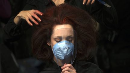 Une mannequin se prot&egrave;ge le visage alors qu'elle se fait coiffer en coulisse de la fashion week&nbsp;Mercedes-Benz&nbsp;&agrave; Madrid (Espagne), le 19 f&eacute;vrier 2013. (SUSANA VERA / REUTERS)