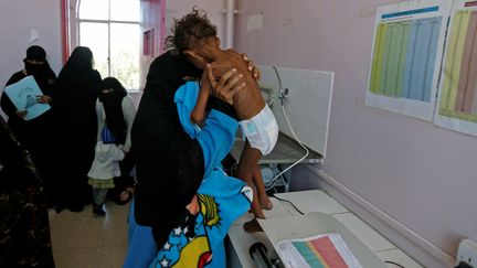 Une femme porte son enfant de cinq ans, victime de malnutrition, à Sanaa, au Yemen, le 22 novembre 2017. (KHALED ABDULLAH / REUTERS)