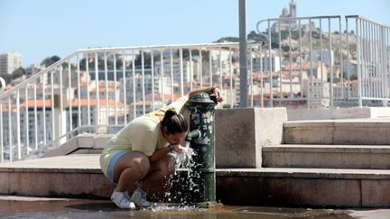 Une femme bois de l'eau sur le vieux port de Marseille (Bouches-du-Rhône), le 21 juillet 2022. (MAXPPP)