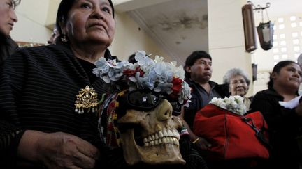 Une femme tient un cr&acirc;ne sur ses genoux lors d'une c&eacute;r&eacute;monie traditionnelle &agrave; La Paz (Bolivie), le 8 novembre 2011. (DAVID MERCADO / REUTERS)