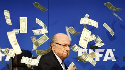 Le président de la Fifa, Sepp Blatter, couvert de faux billets lancés par un humoriste britannique, le&nbsp;20 juillet 2015, à Zurich (Suisse), avant une conférence de presse. (ARND WIEGMANN / REUTERS)