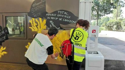 Des militants de l'organisations écologistes Greenpeace et ANV COP21 redécorent une station service Total, le 27 mai 2017. (ANV COP21)