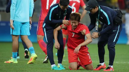 Le footballeur sud-coréen Son Heung-Min est relevé par ses entraîneurs après la défaite de son équipe face au Honduras, en quarts de finale des Jeux olympiques, le 13 août 2016. (YONHAP NEWS / NEWSCOM / SIPA)