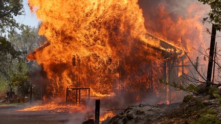 Une maison en flammes, le 23 juillet 2022.&nbsp;L'incendie menace quelques milliers d'habitations dans de petites localités rurales du comté de Mariposa, sur les contreforts de la Sierra Nevada, où plusieurs milliers de personnes sont sous le coup d'ordres d'évacuation. (JUSTIN SULLIVAN / GETTY IMAGES NORTH AMERICA / AFP)