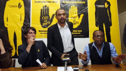 Hermann Ebongué, secrétaire général de SOS Racisme (à droite), aux côtés du président, Dominique Sopo (au centre)&nbsp;et du directeur général, Guillaume Ayne. (PATRICK KOVARIK / AFP)