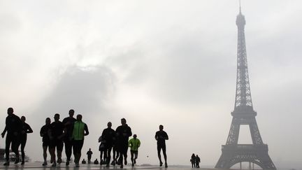 Des joggeurs courent sur l'esplanade du Trocad&eacute;ro en plein pic de pollution aux particules fines, &agrave; Paris, le 11 mars 2014. (LUDOVIC MARIN / AFP)