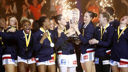 Les joueuses de l'équipe de France de handball lèvent leur trophée de championnes du monde à Hambourg (Allemagne), le 17 décembre 2017 (LAURENT LAIRYS / AFP)