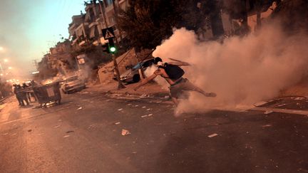 Un manifestant affronte des policiers, le 18 septembre 2013 &agrave; Ath&egrave;nes (Gr&egrave;ce) apr&egrave;s une manifestation&nbsp;le meurtre d'un rappeur anti-fasciste par un militant n&eacute;o-nazi pr&eacute;sum&eacute;. (ARIS MESSINIS / AFP)