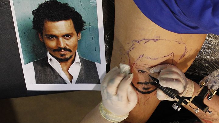 Une femme se fait tatouer un portrait de Johnny Depp sur la cuisse lors d'un salon &agrave; Sydney (Australie), le 8 mars 2013. (DANIEL MUNOZ / REUTERS)