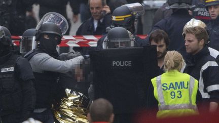 Un homme est arrêté par des membres des forces de l'ordre&nbsp;lors de l'intervention antiterroriste à Saint-Denis (Seine-Saint-Denis), le 18 novembre 2015. (PETER DEJONG / AP / SIPA)