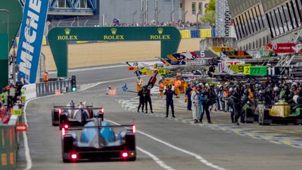 Des pilotes de course se dirigent vers les stands, le 16 juin 2024, lors des 24 Heures du Mans. (GUILLAUME SOUVANT / AFP)