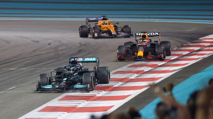 La Mercedes de Lewis Hamilton devant la Red Bull de Max Verstappen, lors du Grand Prix d'Abu Dhabi, le 12 décembre 2021. (GIUSEPPE CACACE / AFP)