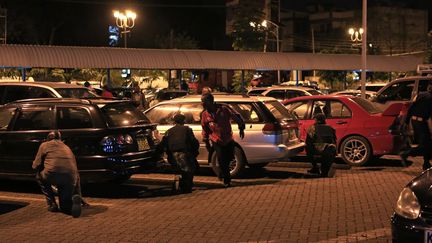 Des civils se cachent &agrave; l'ext&eacute;rieur du centre commercial Westgate vis&eacute; par une attaque terroriste, &agrave; Nairobi (Kenya) le 21 septembre 2013.&nbsp; (NOOR KHAMIS / REUTERS)