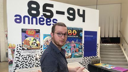 Bertrand Brie, commissaire de l'exposition "50 ans du Concours de la BD scolaire", devant le stand des années 1985-1994. (MOHAMED BERKANI)