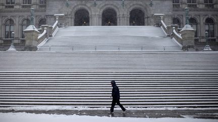 Un homme marche dans la ville d'Albany (Etats-Unis), ville où le gourou Keith Raniere a&nbsp;basé son organisation NXIVM. (MIKE SEGAR / REUTERS)