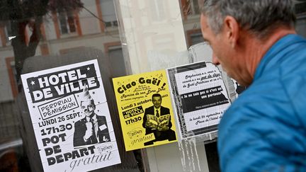 Un homme lit des tracts contre le maire de Saint-Etienne (Loire) Gaël Perdriau, le 21 octobre 2022 (REMY PERRIN / MAXPPP)