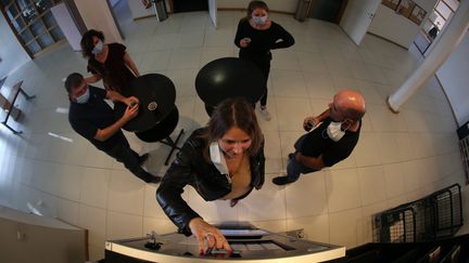 Des salariés lors de leur pause café autour de la machine&nbsp;à café dans leur entreprise à Mulhouse, le 25 mars 2021. (JEAN-FRAN?OIS FREY / MAXPPP)