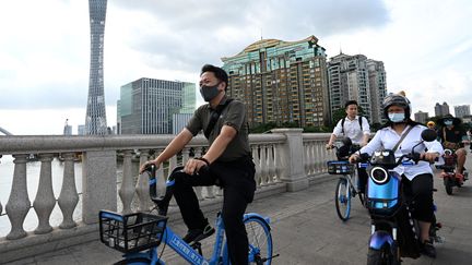 Des cyclistes dans les rues de Guangzhou (Chine), le 24 mai 2021. (NOEL CELIS / AFP)