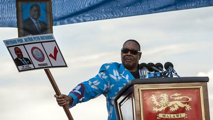 Le président sortant du Malawi,&nbsp;Peter Mutharika, montre un bulletin de vote factice à son effigie, lors du lancement de sa campagne électorale, le 7 avril 2019 à Lilongwe, la capitale du pays. (AMOS GUMULIRA / AFP)