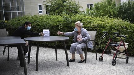 La résidente d'un Ehpad reçoit un cadeau de son petit-fils à l'occasion de la fête des mères à Saint-Maur-des-Fosses&nbsp;(Val-de-Marne), le 7 juin 2020. (ANNE-CHRISTINE POUJOULAT / AFP)