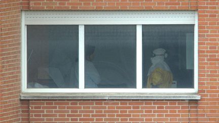 Une &eacute;quipe m&eacute;dicale au sixi&egrave;me &eacute;tage de l'h&ocirc;pital Carlos III de Madrid (Espagne), l&agrave; o&ugrave; est trait&eacute;e l'aide-soignante espagnole, jeudi 9 octobre 2014.&nbsp; (CURTO DE LA TORRE / AFP)