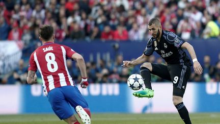 Saul Niguez,&nbsp;de l'Atletico Madrid, et Karim Benzema, du Real Madrid, s'affrontent en demi-finale de la Ligue des champions, à Madrid le 10 mai 2017. (BURAK AKBULUT / ANADOLU AGENCY / AFP)