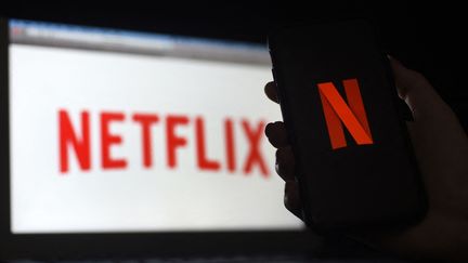 Un ordinateur et un smartphone connectés sur la plateforme Netflix, en mars 2020. (OLIVIER DOULIERY / AFP)