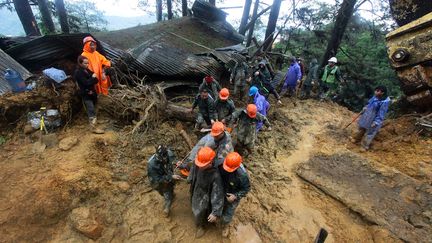 Des secouristes évacuent un des corps emporté par une coulée de boue à Baguio au nord de Manille, le 16 septembre 2018.&nbsp; (JJ LANDINGIN / AFP)