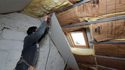 Un artisan travaille sur la rénovation thermique d'une maison. (illustration) (FRANCOIS DESTOC / MAXPPP)